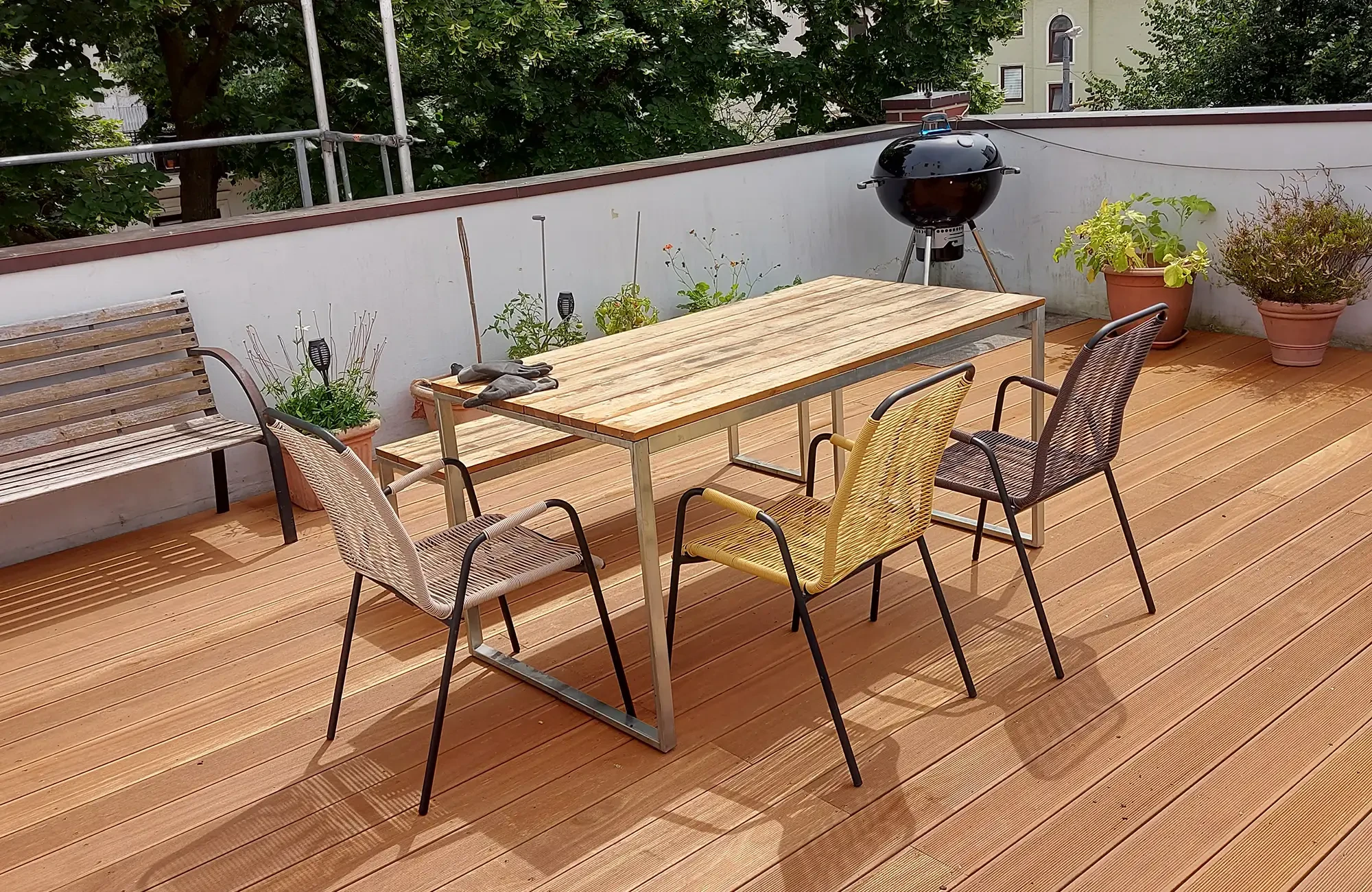 Terrassendielen Reparatur – frisch instandgesetzte Holzterrasse mit Gartenmöbeln und Grill