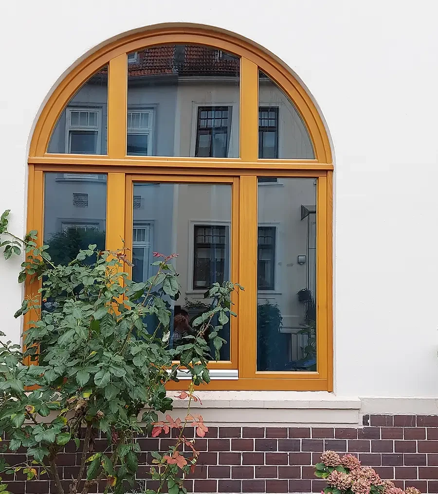 Holzfenster mit Rundbogen in einer Hausfassade, modernes Design