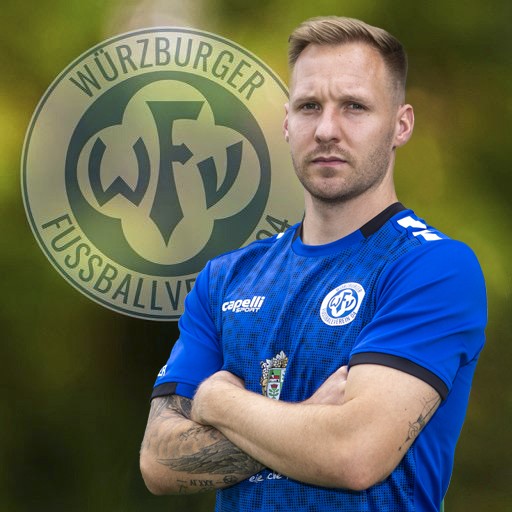 Fußballspieler des Würzburger FV in blauem Trikot vor Vereinslogo