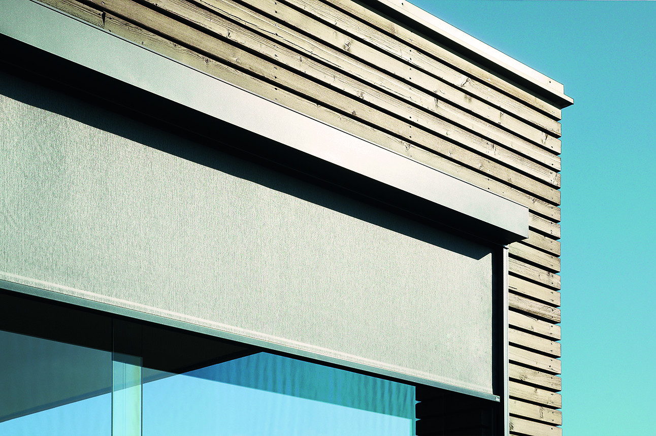 Moderner textiler Sonnenschutz an einer Holzfassade, Detailaufnahme eines ZIP-Screens