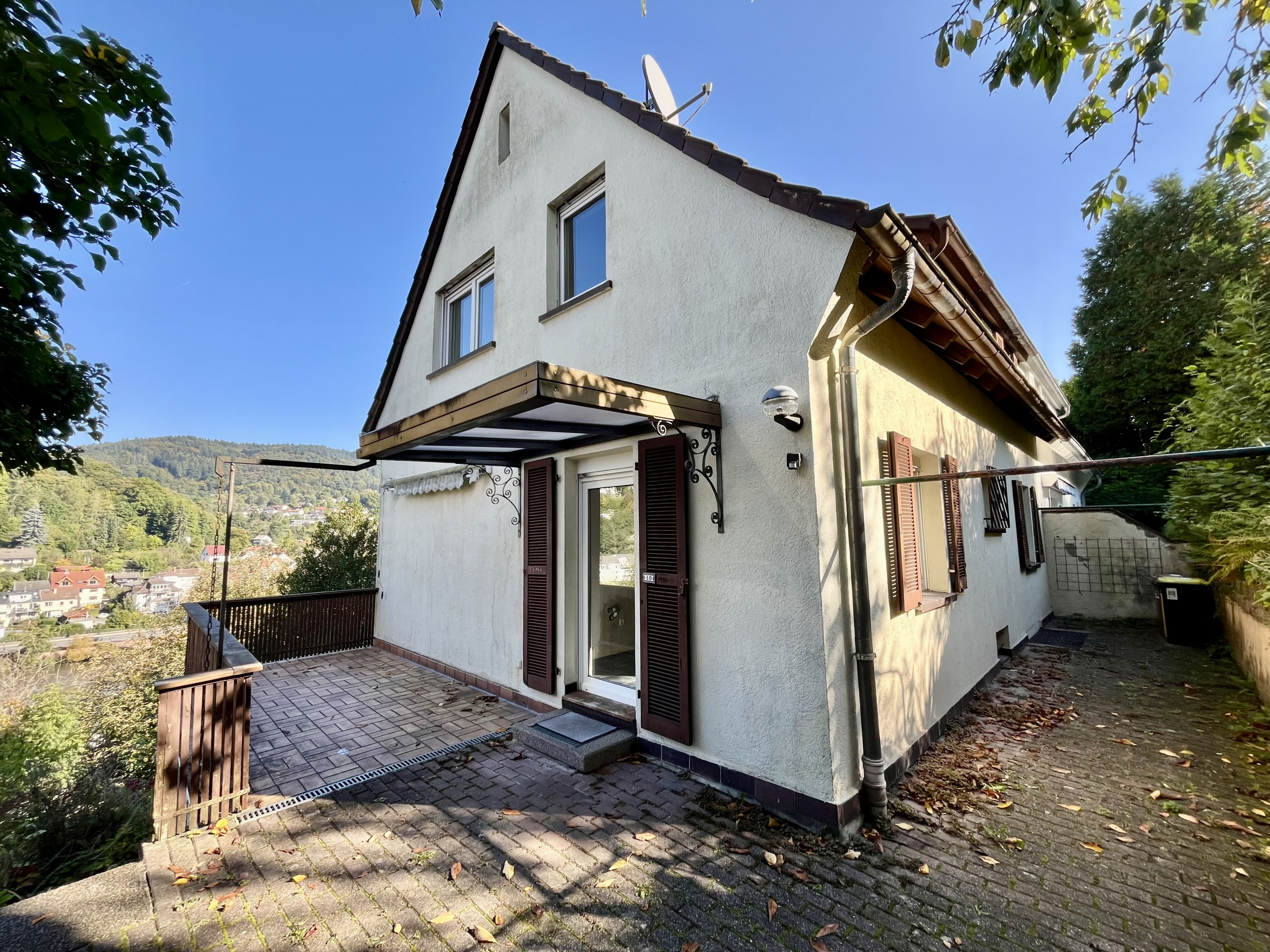 Freistehendes Einfamilienhaus mit Terrasse und Blick ins Grüne an einem sonnigen Tag