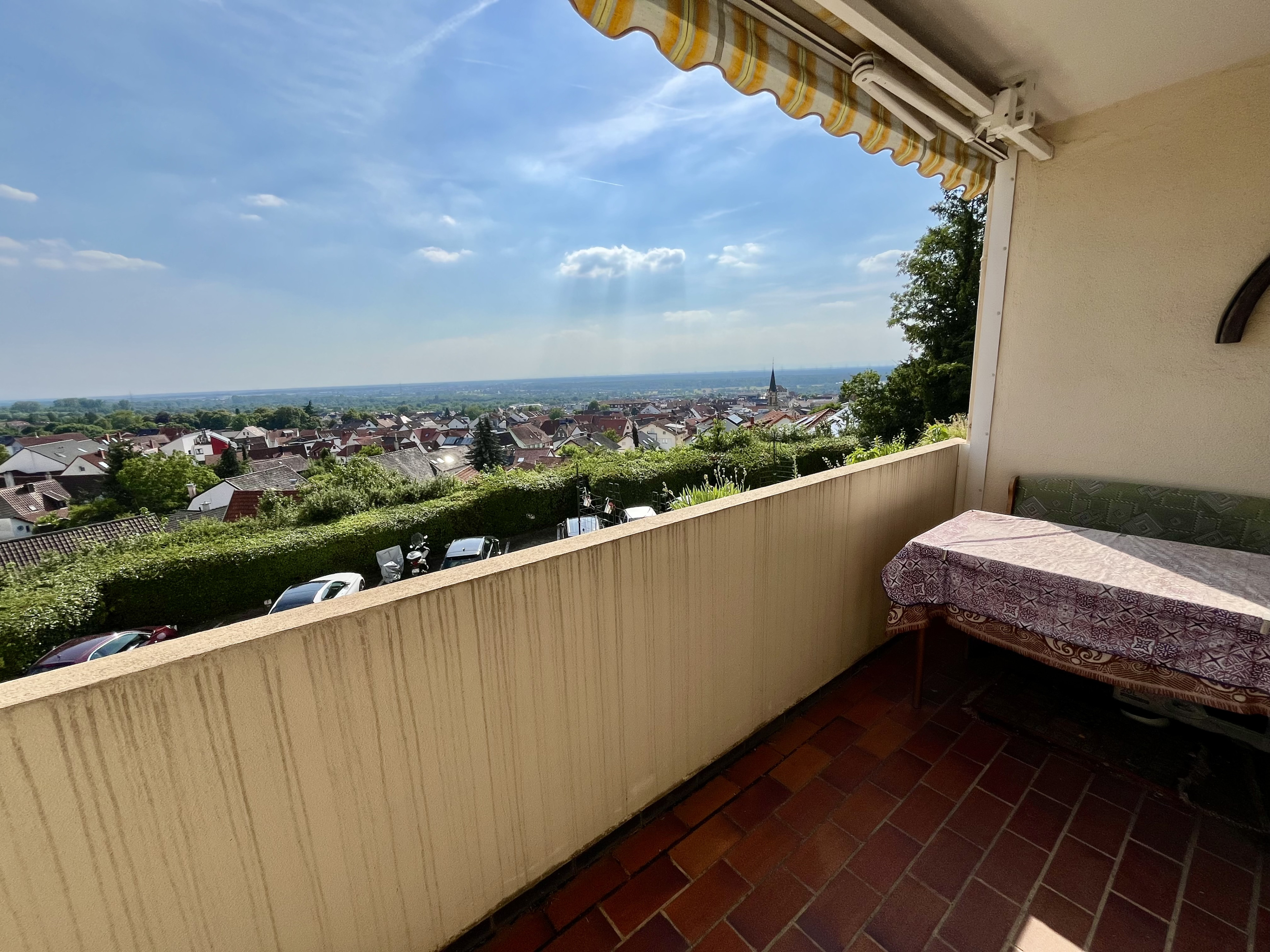 Balkon mit Ausblick auf eine Stadtlandschaft bei sonnigem Wetter