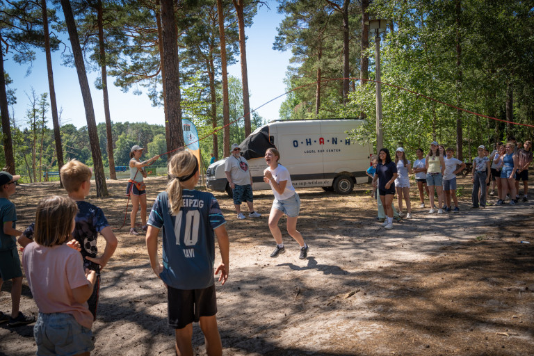 Jugendliche beim Spielen im Frauenwald mit Ohana SUP Center im Hintergrund