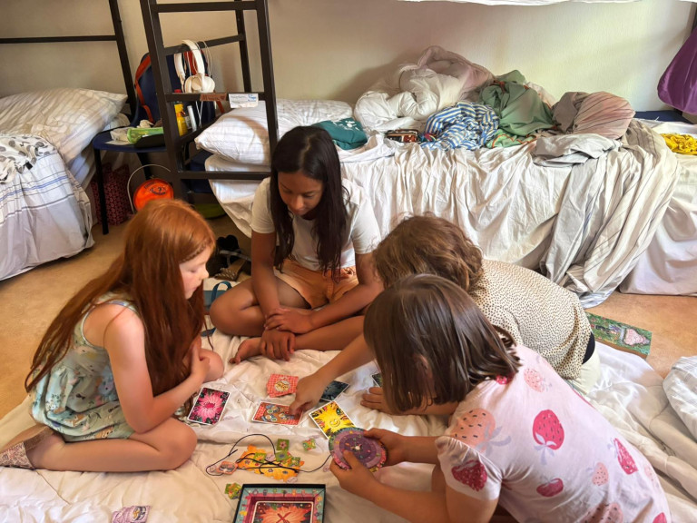 Kinder spielen ein Brettspiel im Schlafzimmer auf dem Boden.