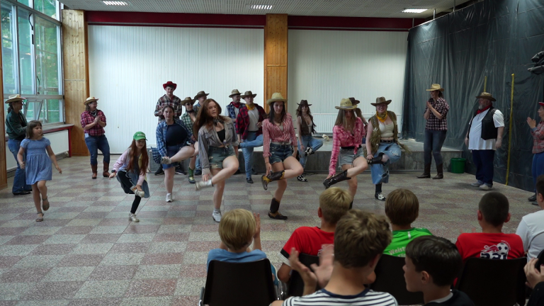 Kulturabend mit Country-Tanzaufführung Gruppe von Menschen in Cowboy-Kleidung bei einem Kulturabend-Tanzauftritt