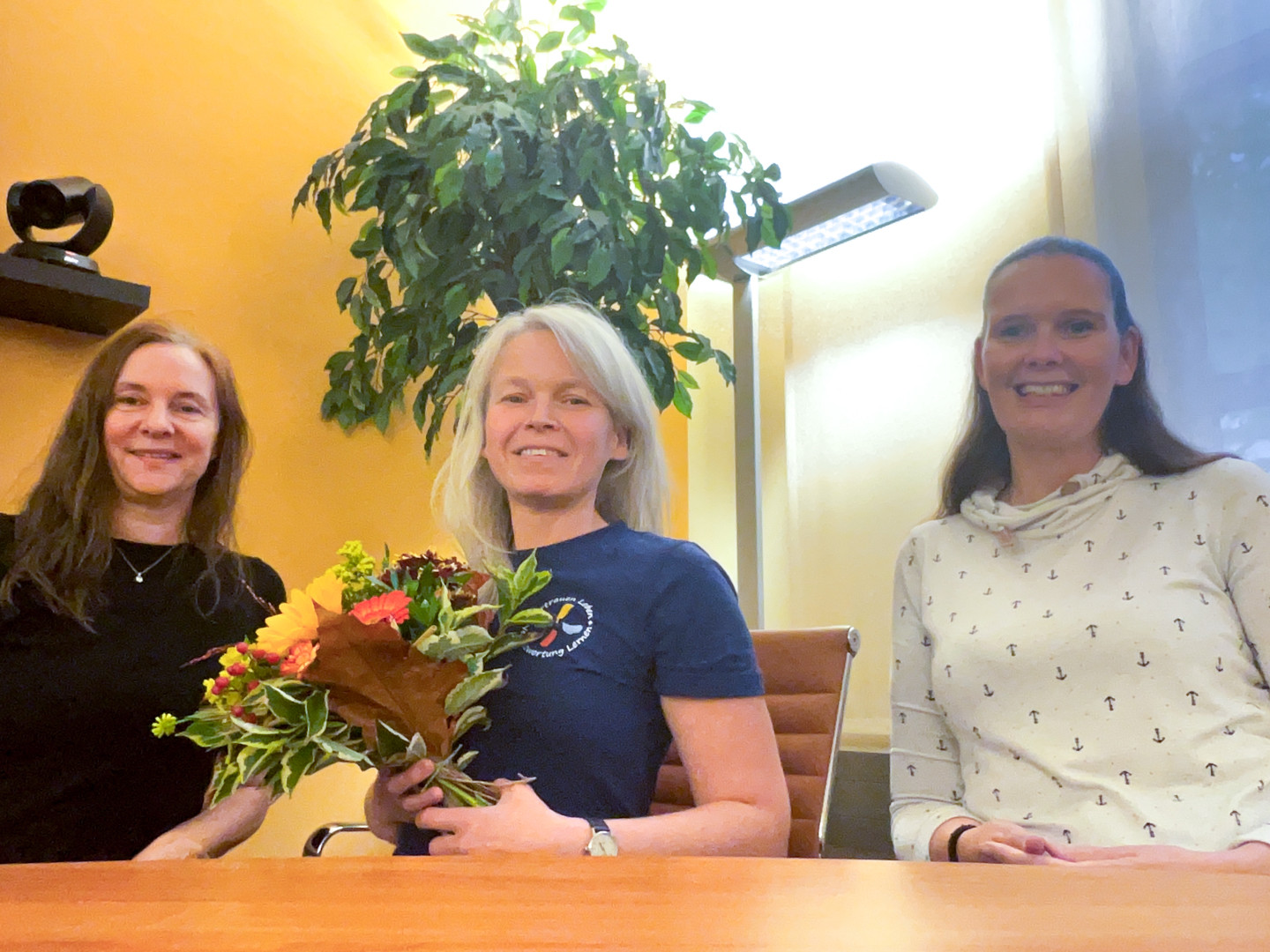 Spendenübergabe im Muldental – Gruppenfoto mit Blumenstrauß Spendenübergabe im Muldental: Drei Frauen sitzen an einem Tisch, eine hält einen Blumenstrauß