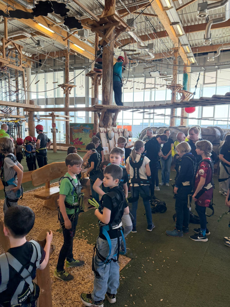 Kinder und Erwachsene im Indoor-Kletterpark beim Sicherheitsbriefing, Kletterpark-6