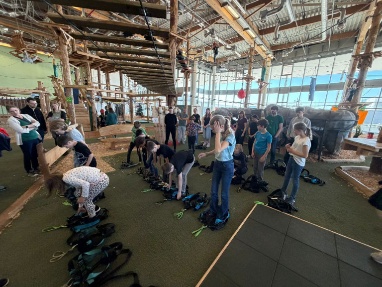 Kindergruppe bereitet sich im Indoor-Kletterpark auf das Klettern vor