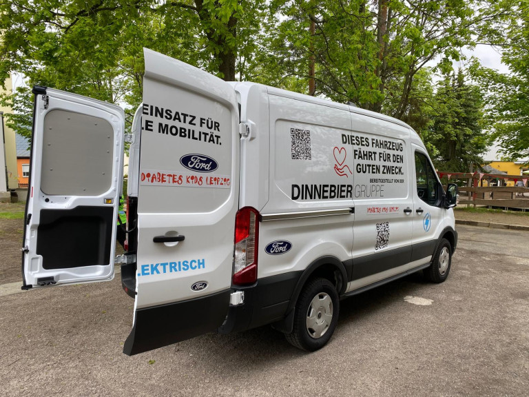 Elektrischer Transporter der Dinnebier Gruppe beim Frühlingsfest am Evangelischen Schulzentrum Muldental, mit Ford-Logo und Aufschrift für den guten Zweck.