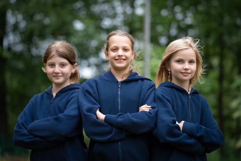Ferienfreizeitlager Seifhennersdorf: Drei Mädchen in blauen Hoodies im Sommerlager Drei Mädchen in blauen Hoodies beim Ferienfreizeitlager in Seifhennersdorf, lächelnd im Freien