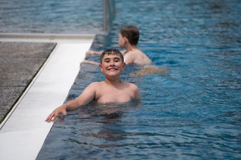 Junge im Freibad Seifhennersdorf beim Schwimmen am 26.07.2007 Junge beim Schwimmen im Freibad Seifhennersdorf, lächelnd am Beckenrand