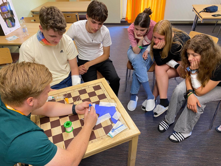 Erste-Hilfe-Workshop fr Jugendliche am Schachbrett-Tisch im Seminarraum Jugendliche lernen Erste Hilfe am Schachbrett-Tisch in einem Seminarraum