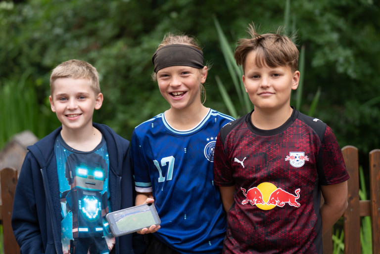 Jungen beim FFZ26 Seifhennersdorf mit Fußballtrikots und Smartphone, 26.07.2007 Drei Jungen beim FFZ26 in Seifhennersdorf, einer hält ein Smartphone mit Fußballspiel, zwei tragen Fußballtrikots von Deutschland und RB Leipzig