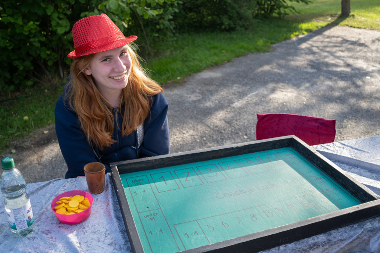 Junge Frau mit rotem Hut am Spieltisch bei FFZ26 in Seifhennersdorf am 26.07.2008 Junge Frau mit rotem Hut bei einem Spieltisch in Seifhennersdorf, FFZ26, draußen im Sommer