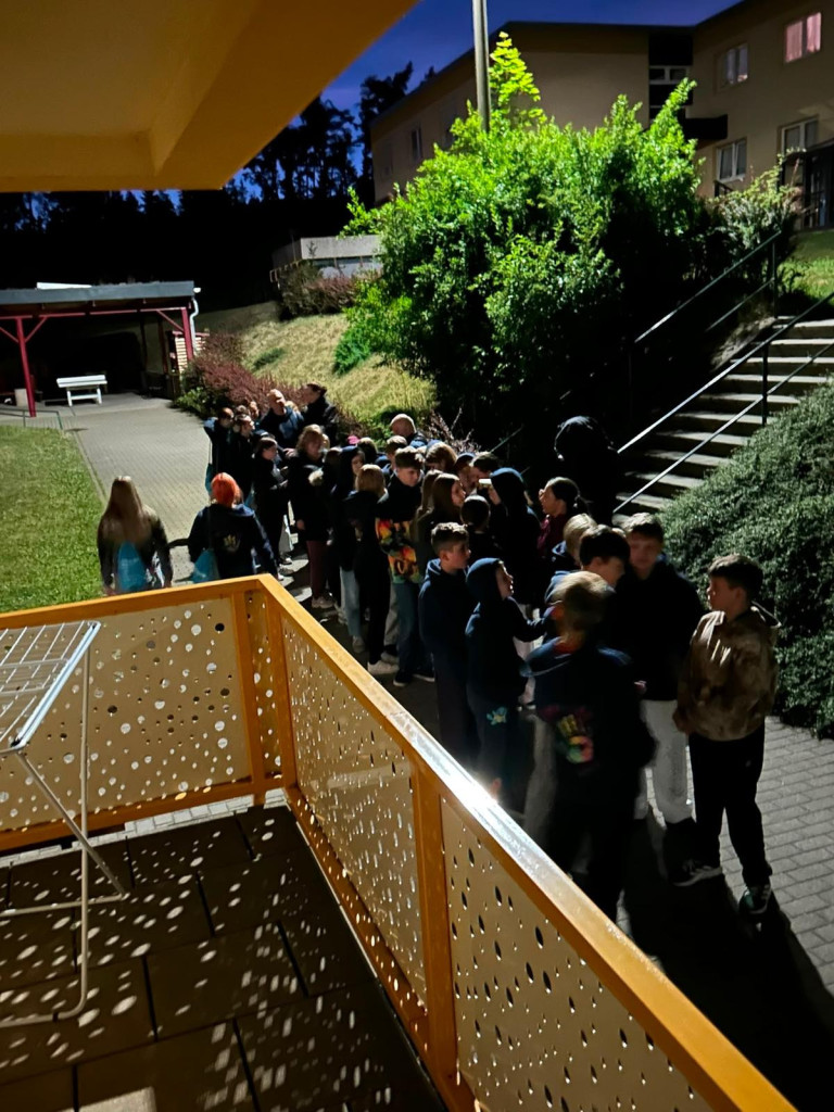 Jugendgruppe bei nächtlicher Veranstaltung im Freien vor Jugendherberge, aufgenommen am 09.07.2026 Gruppe von Jugendlichen bei einer Nachtwanderung oder Abendveranstaltung im Freien vor einer Jugendherberge