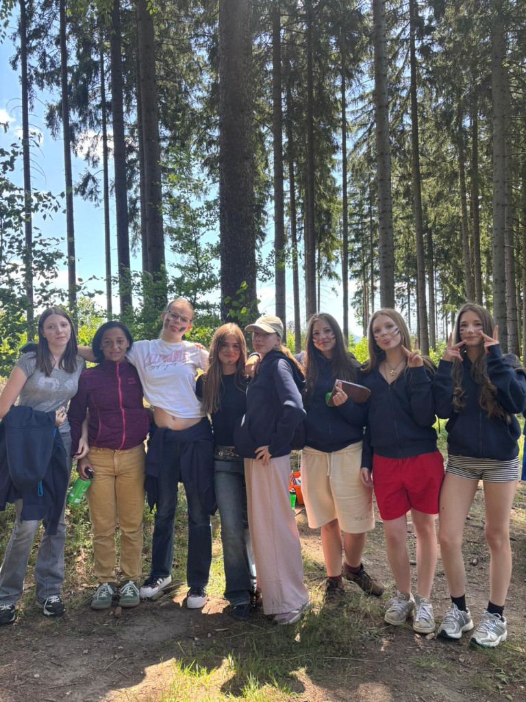 Jugendliche genießen Freizeit im Wald bei schönem Wetter, Gruppenfoto im Ferienlager Gruppe von Jugendlichen im Wald bei sonnigem Wetter, Freizeitaktivität oder Ferienlager