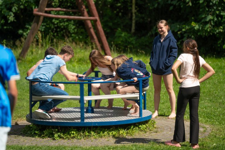 Jugendliche auf einem Karussell im Freien in Seifhennersdorf Jugendliche beim Spielen auf einem Karussell im Freien in Seifhennersdorf