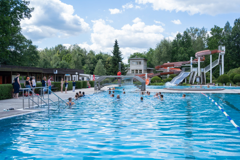 Freibad Seifhennersdorf mit Wasserrutsche und Badegästen im Sommer Freibad in Seifhennersdorf mit Wasserrutsche und Badenden an einem Sommertag