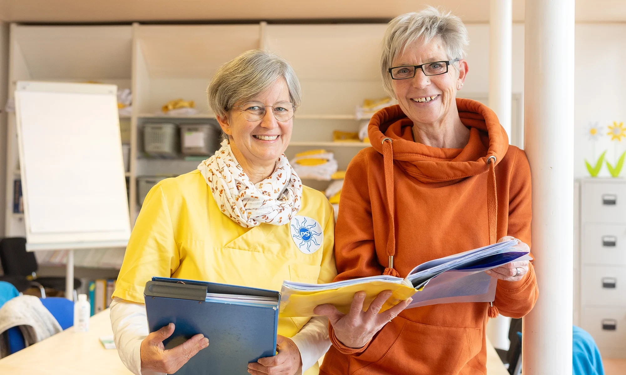Aktuelles: Zwei Personen bei der Arbeit mit Unterlagen und Akten Zwei Personen im Arbeitsumfeld mit Aktenordnern und Unterlagen, Symbolbild für aktuelle Informationen