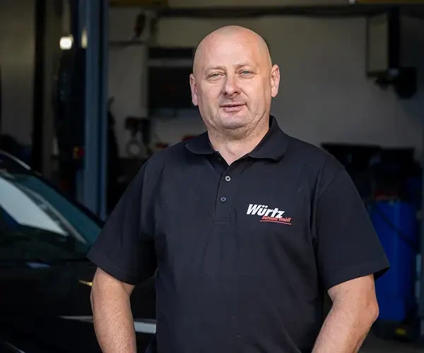 Roman Bergstreiser vor einer Werkstatt, mit Würtz AutoMobil Shirt