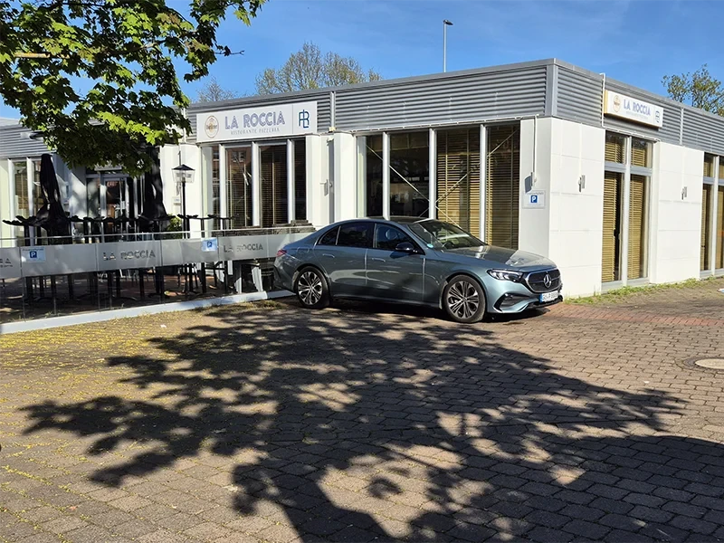 Parkplatz vor dem Restaurant La Roccia mit geparktem Mercedes-Benz