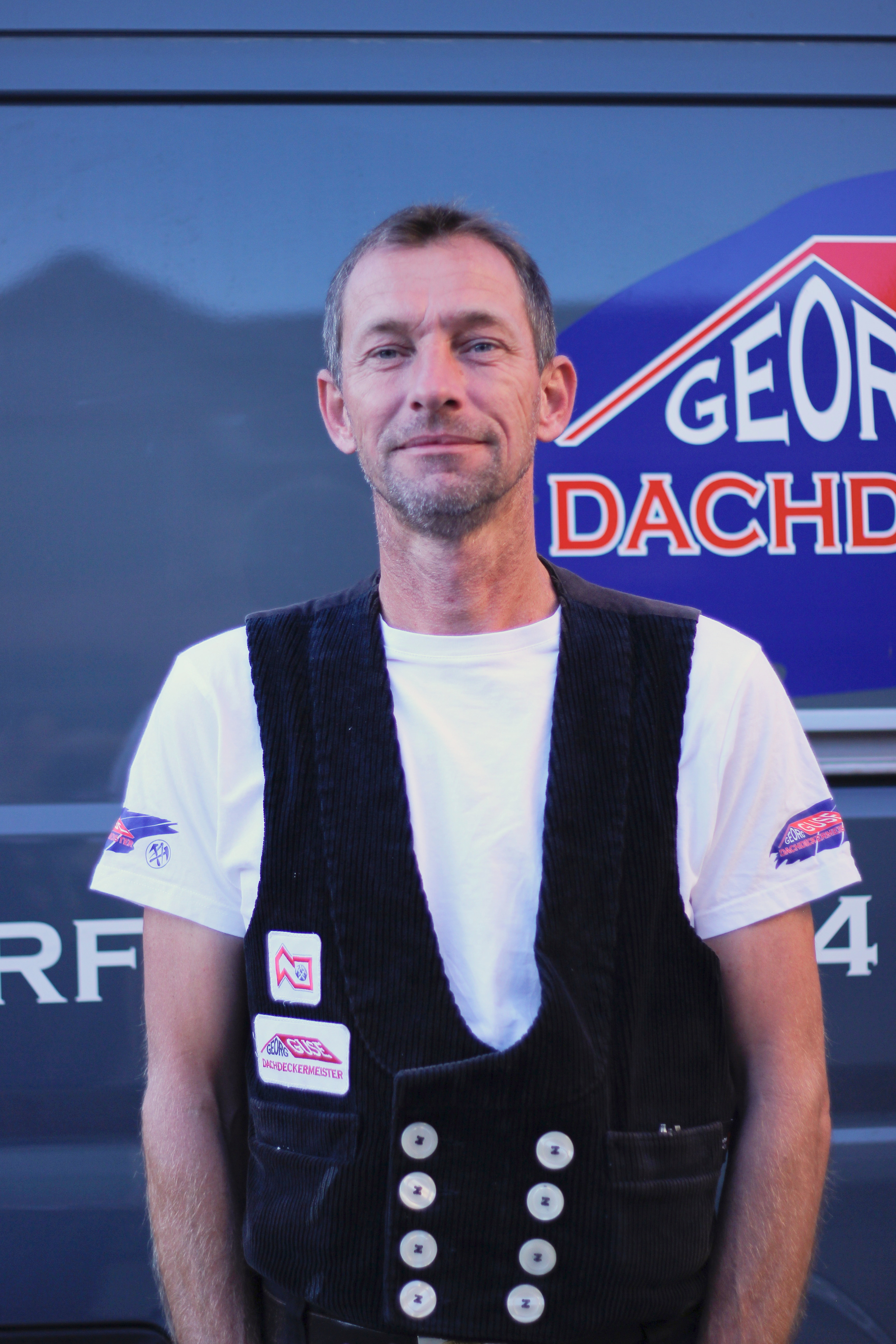Fachgeselle Gabriel Lahmann vor Firmenfahrzeug der Dachdeckerei