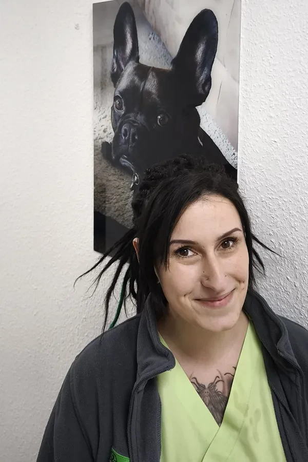 Frau Kunth vor einem Bild mit schwarzem Hund an einer weißen Wand