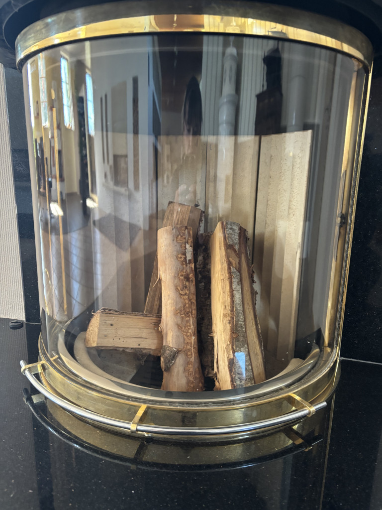 Kamin mit Holzscheiten hinter Glas – modernes Kamin-Design fr Blog Kamin mit Holzscheiten hinter Glas, reflektierende Umgebung, modernes Kamin-Design
