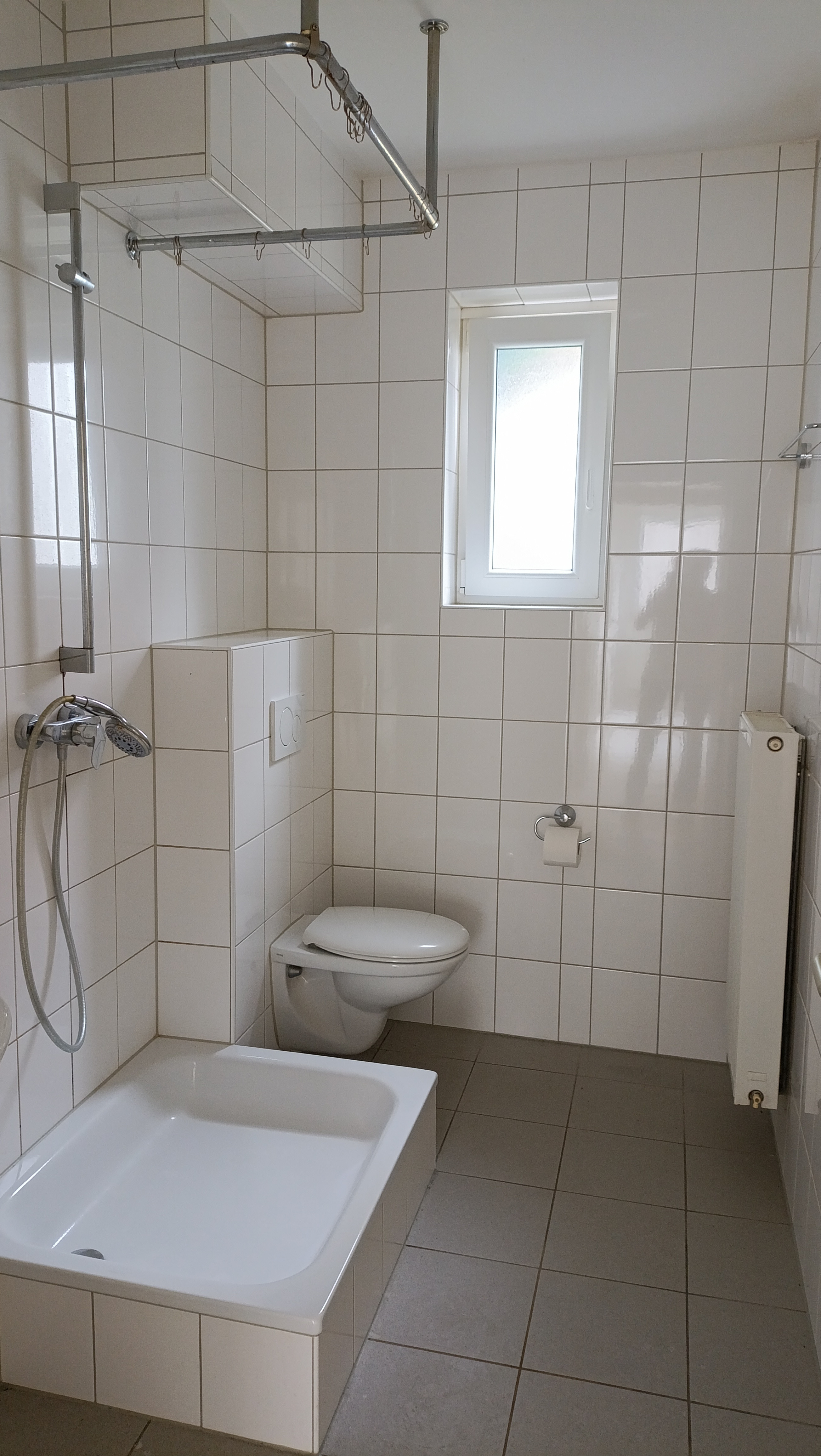 Modernes Badezimmer mit Dusche, Toilette und Fenster
