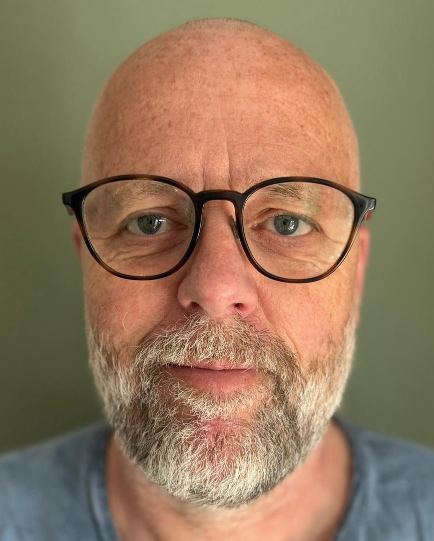 Porträt eines älteren Mannes mit Brille vor grünem Hintergrund, aufgenommen am 06.04.2026