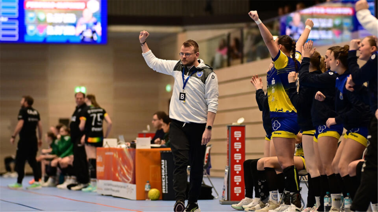 Handballtrainer und Spielerinnen von Buxtehude jubeln während eines Spiels