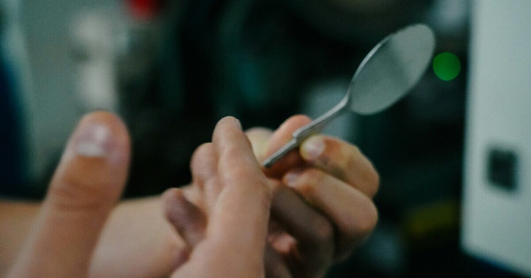 Person hält einen Löffel in der Hand