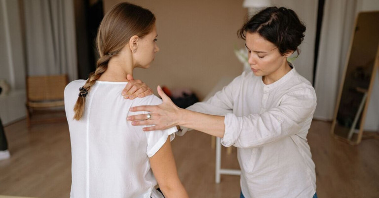 Physiotherapeutin behandelt eine Patientin mit Frozen Shoulder