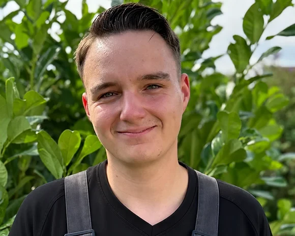 Porträt von Marcel Möller vor grünen Pflanzen