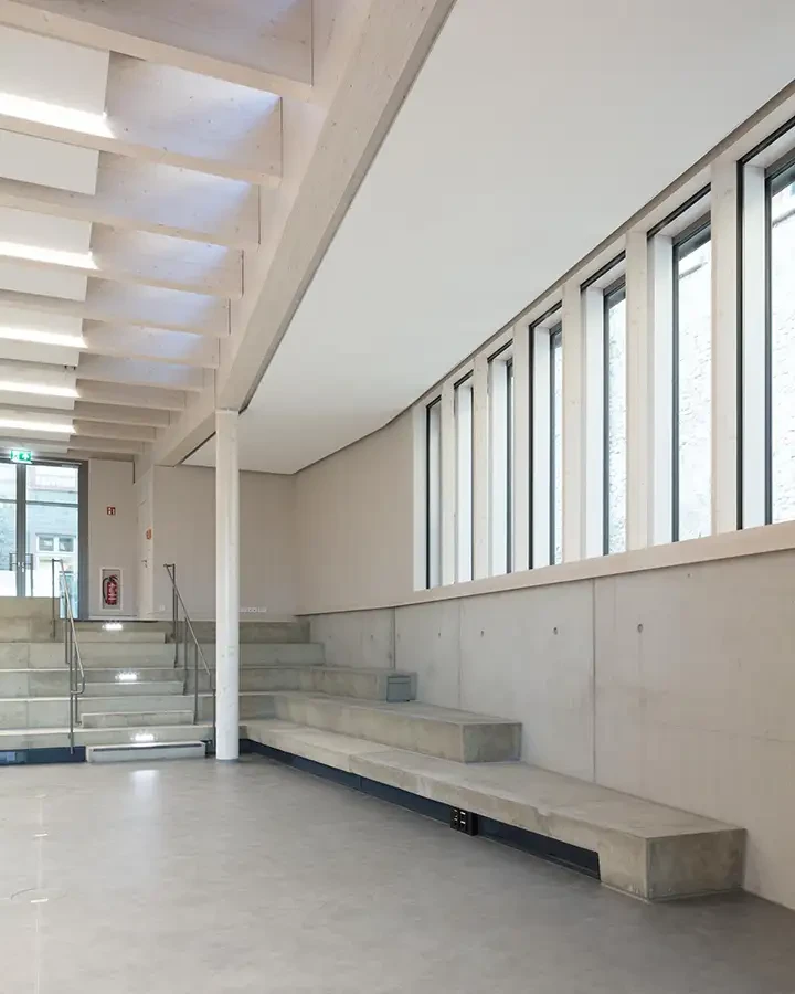 Moderner Innenraum mit Betonstufen und großen Fenstern, minimalistische Architektur