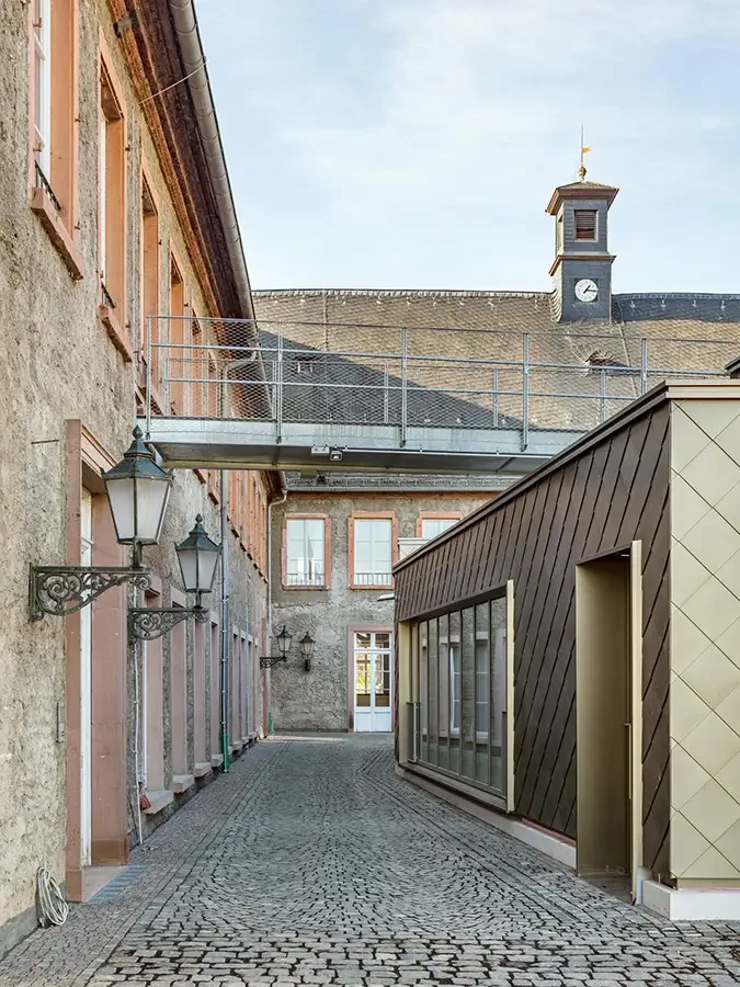 Innenhof mit historischem Gebäude, moderner Architektur und Uhrenturm
