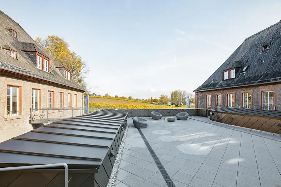 Moderne Dachterrasse mit Ausblick auf Weinberge und stilvollen Sitzgelegenheiten