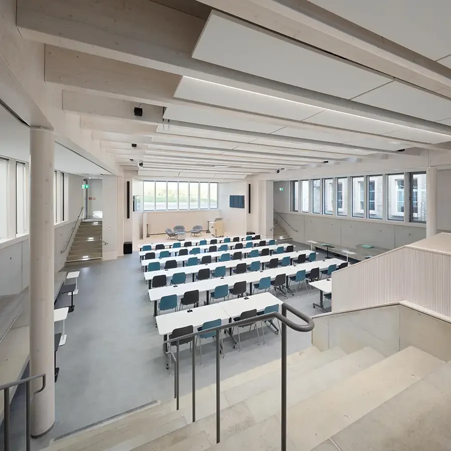 Moderner, heller Hörsaal mit Reihen von Tischen und Stühlen in einem Universitätsgebäude