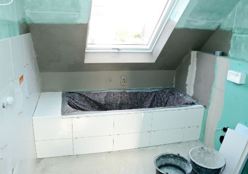 Badezimmer-Sanierung mit neuer Badewanne und Fliesen unter Dachschräge