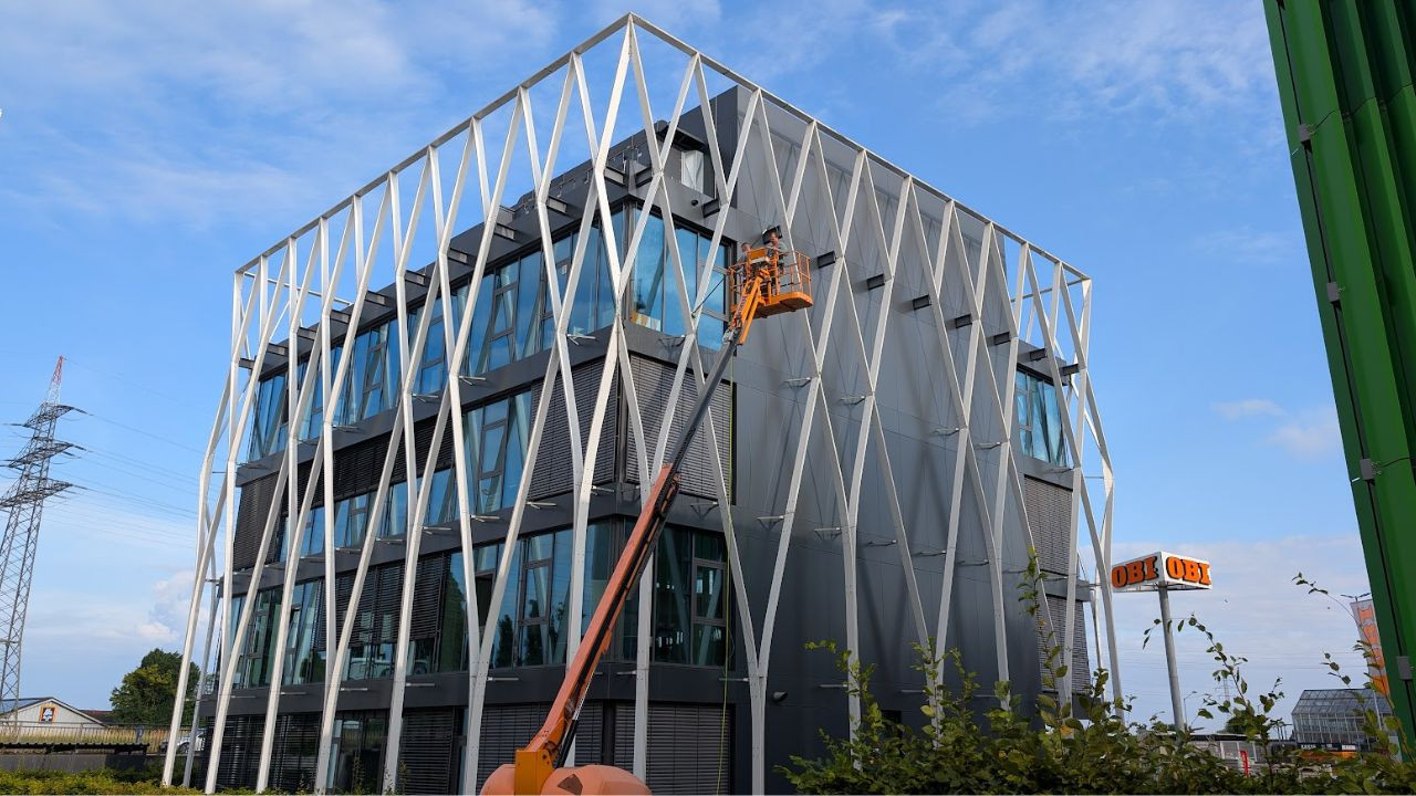 Professionelle Glasreinigung in Offenburg nahe OBI an moderner Gebäudefassade Fassaden- und Glasreinigung in Offenburg nahe OBI mit Hebebühne an modernem Bürogebäude