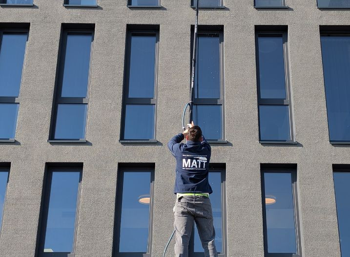 Gebäudereiniger bei der Fensterreinigung an einem Bürogebäude in Offenburg – Job in der Gebäudereinigung