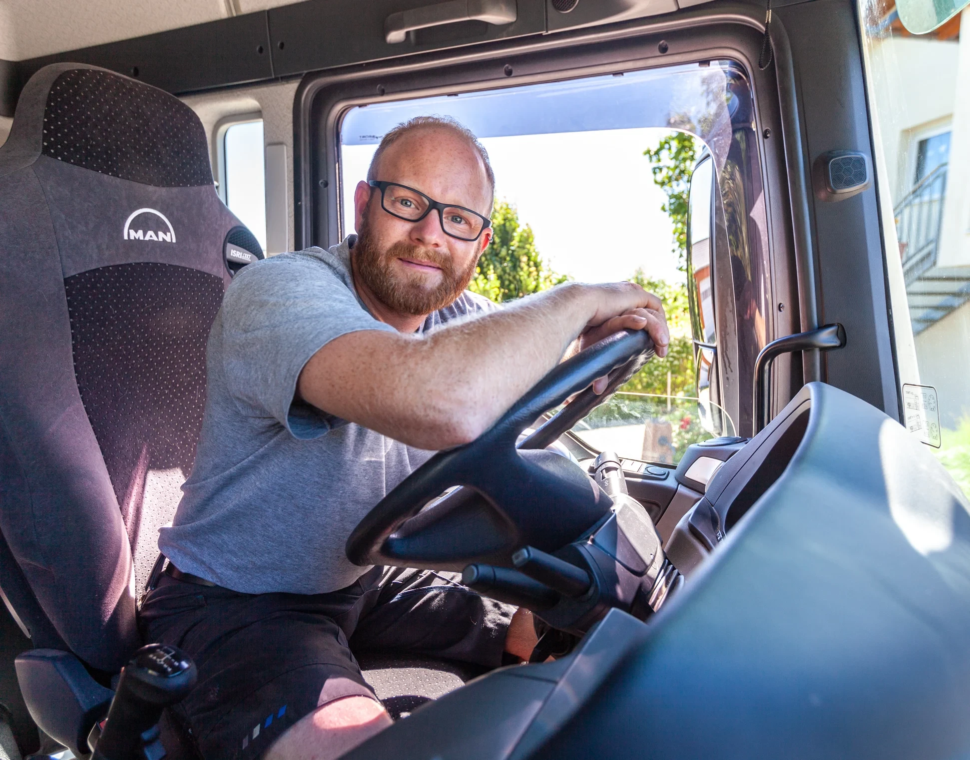 Lkw-Fahrer im Fahrerhaus eines MAN-Lkw Lkw-Fahrer sitzt am Steuer eines MAN-Lkw