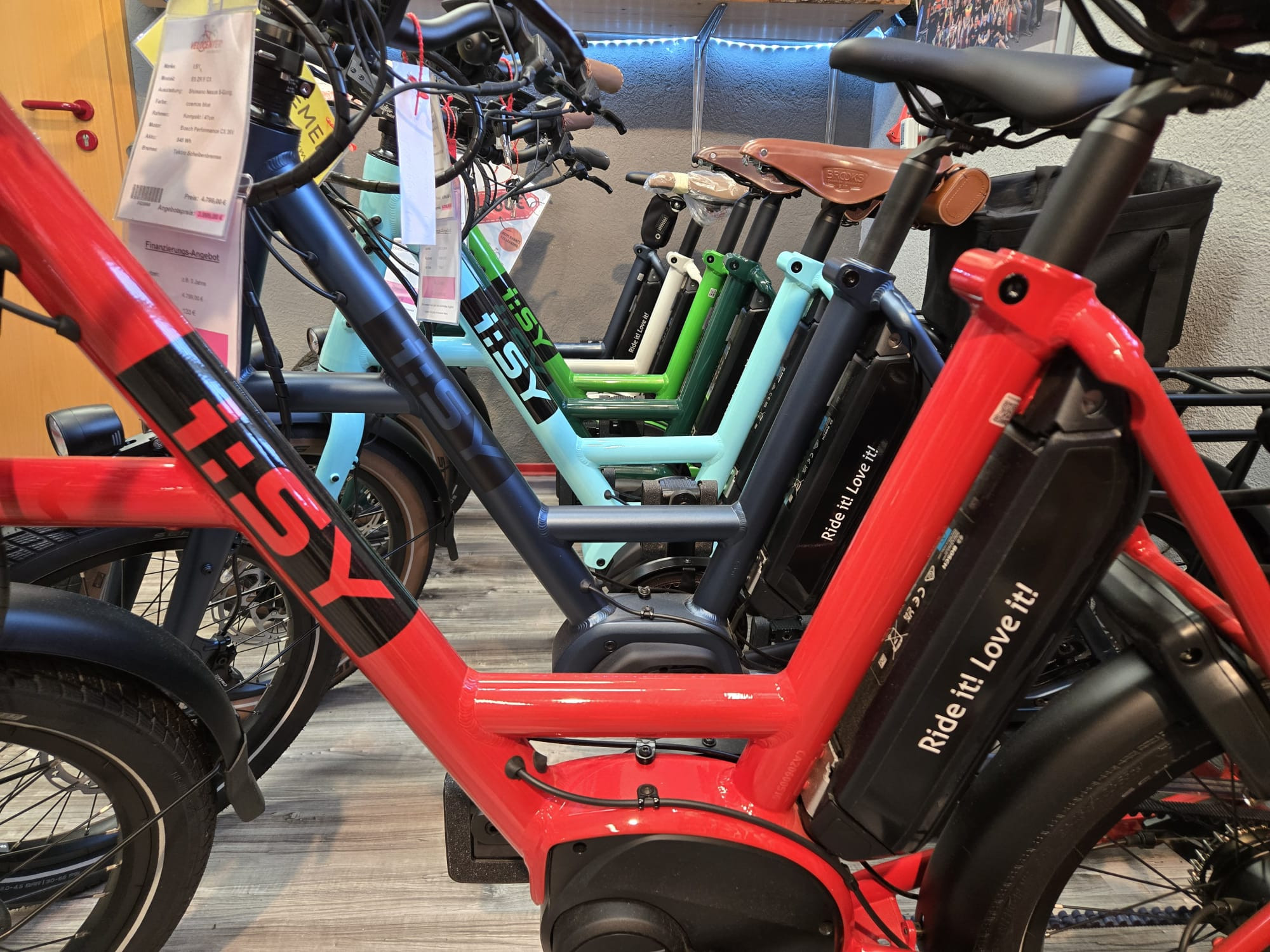 Mehrere i:SY E-Bikes in verschiedenen Farben in einer Fahrrad-Ausstellung