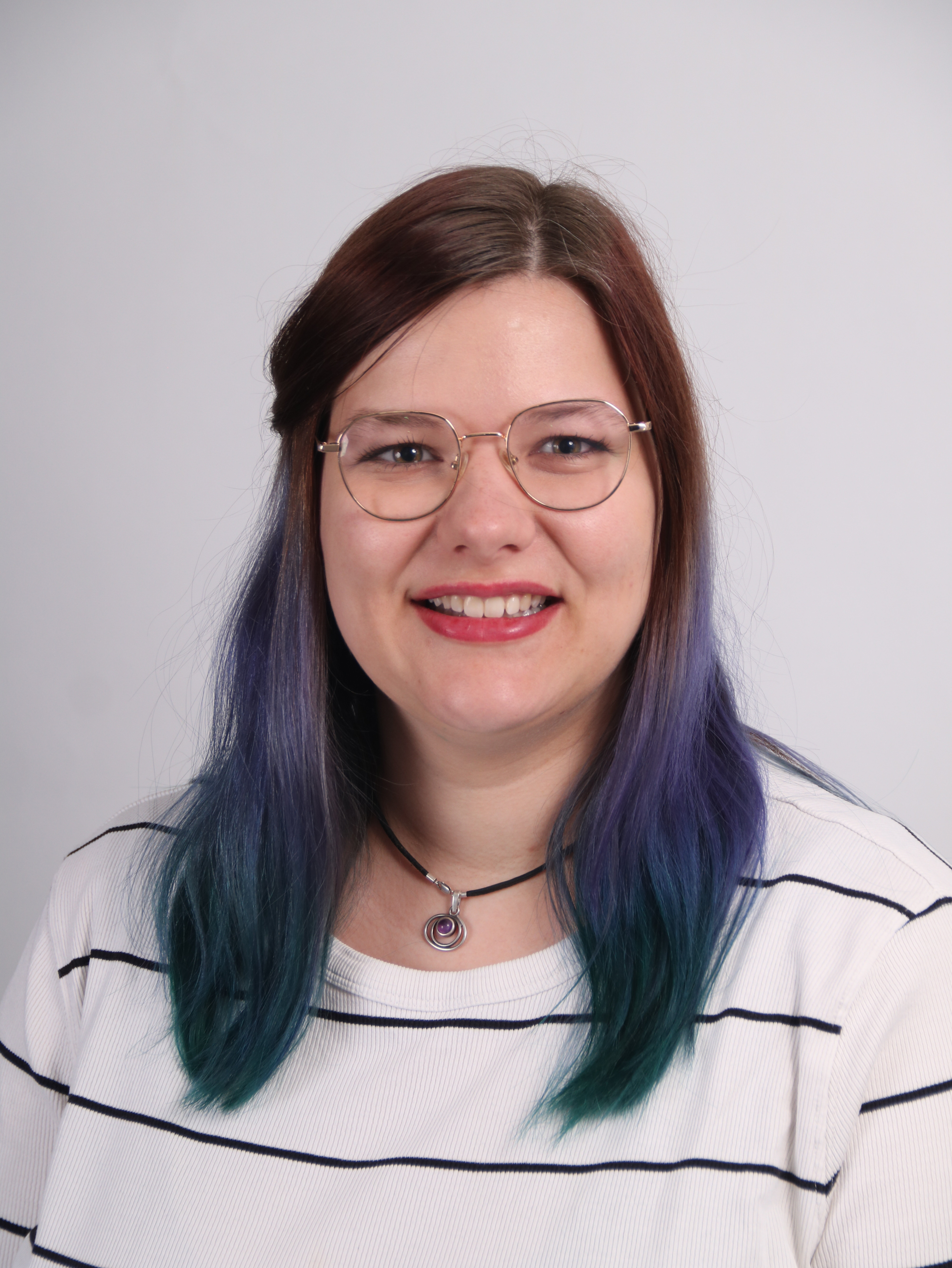 Porträtfoto von Jana Rauber mit Brille und lila Haaren