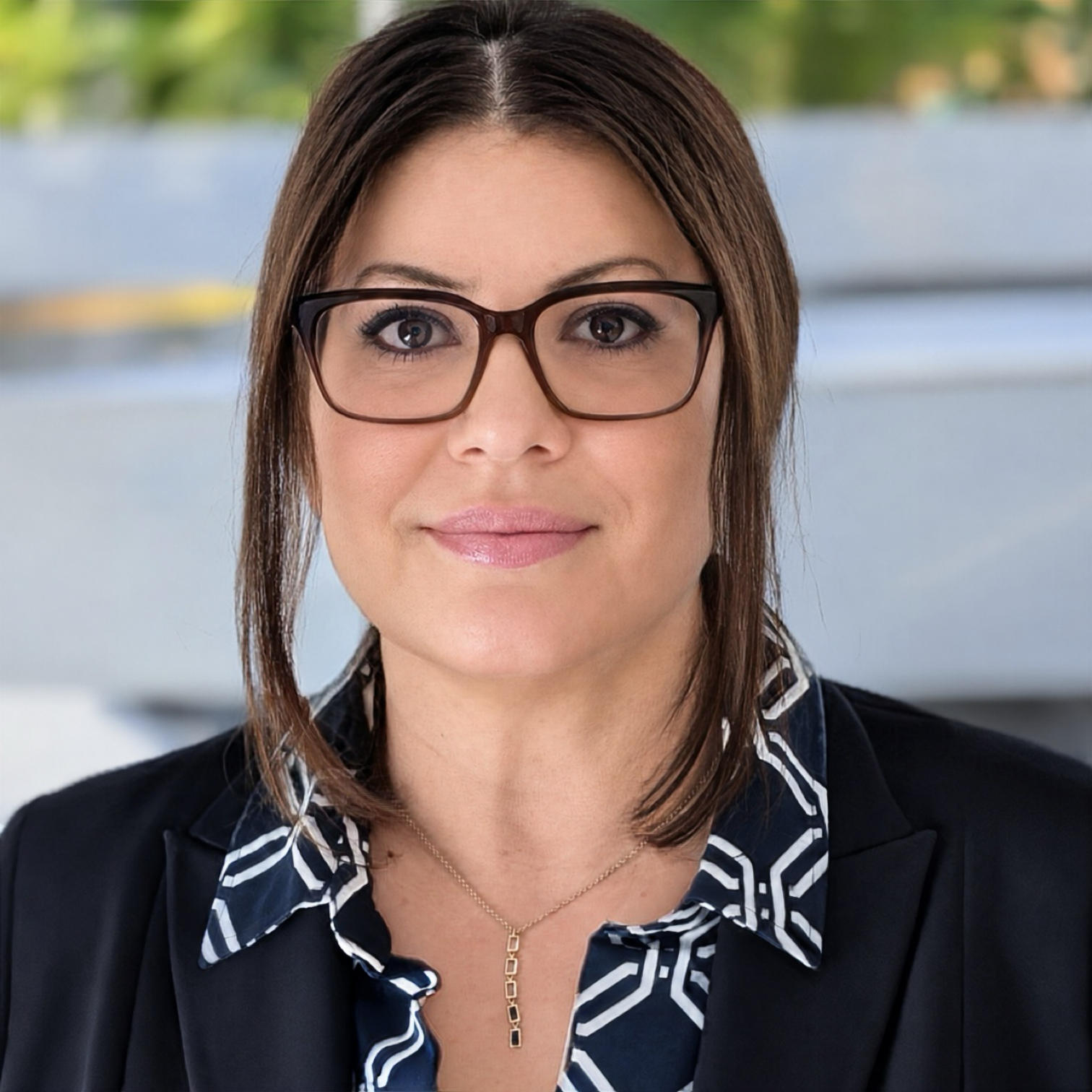 Porträt einer Frau mit Brille im Business-Outfit, Symbolbild für Frau Klima