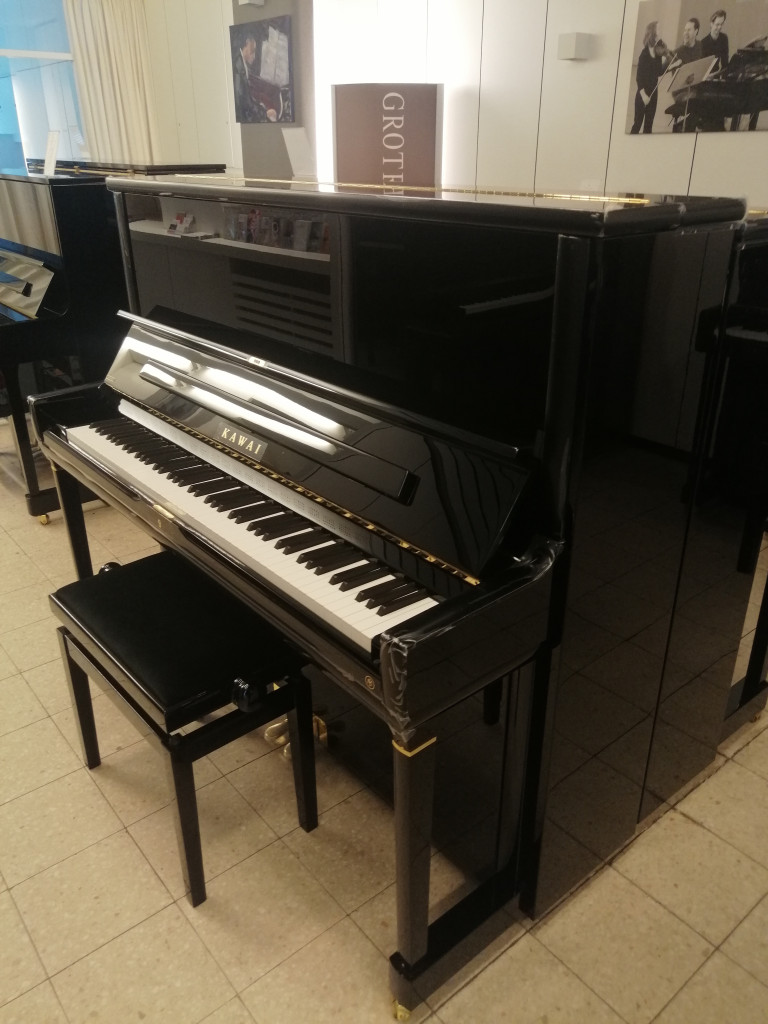 Schwarzes Kawai Klavier mit Klavierbank in einem Musikgeschäft