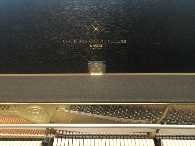Kawai Klavier Detailaufnahme mit Schriftzug 'The Future of the Piano' und Mechanik Detailansicht eines Kawai Klaviers mit der Aufschrift 'The Future of the Piano' und sichtbaren Mechanikteilen