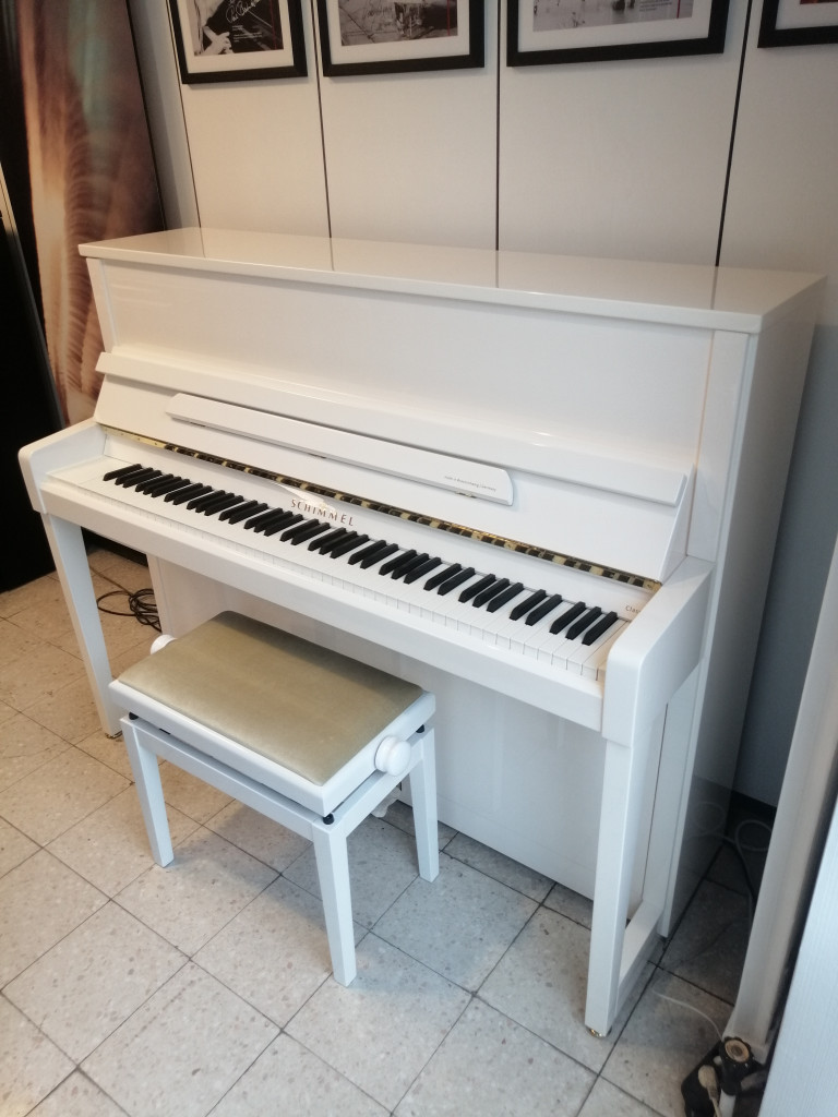 Weißes Schimmel Klavier mit Klavierbank in modernem Raum