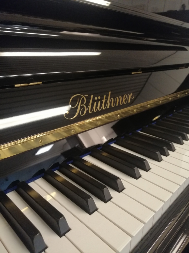 Blüthner Klavier Nahaufnahme der Klaviatur und Markenlogo