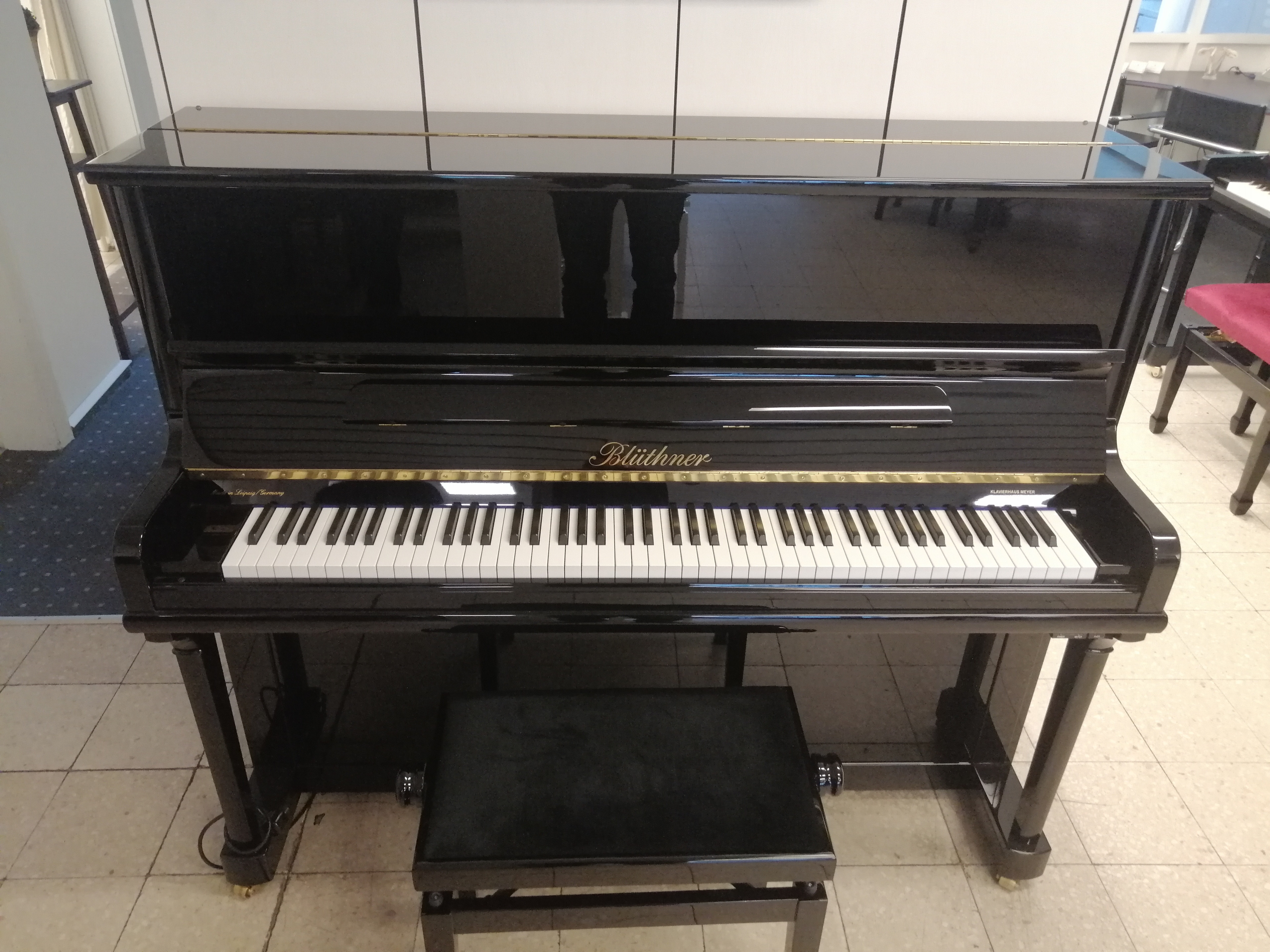 Blüthner Klavier schwarz mit Klavierbank in einem Musikraum